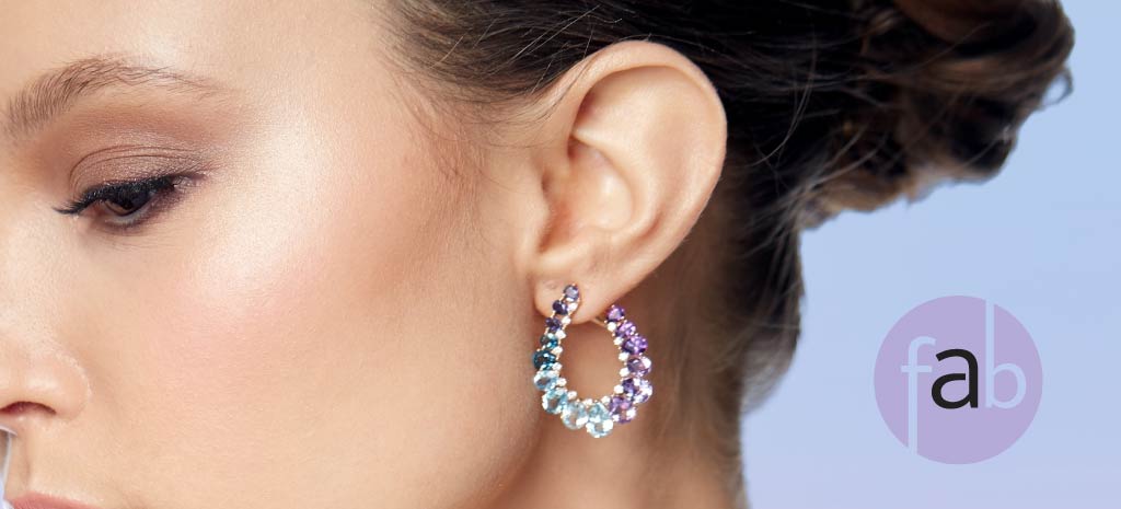 Gorgeous female showing off her newly repaired earlobe with earrings. Simulated.